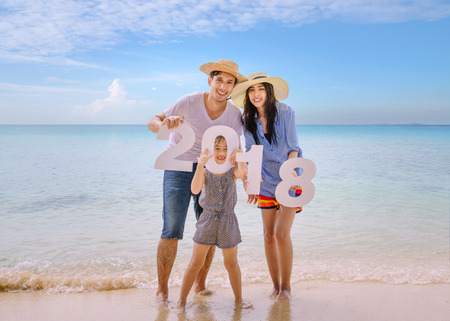 Family holding number 2018 on the beachの写真素材