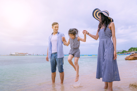 Happy family playing on the beach at the day time.の写真素材