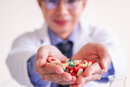 Medicine doctor with a lot of pills in palm hand on laboratory.の写真素材