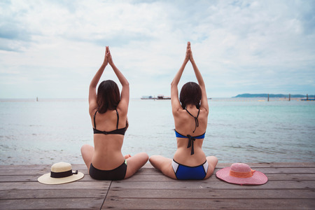 Beautiful women doing yoga at the beach.の写真素材