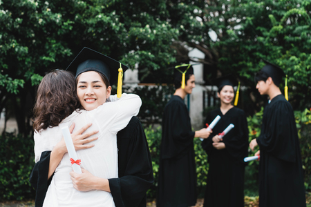 A graduate hugging her mother.の写真素材