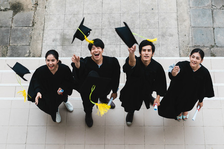 People students in the feeling of happy and graceful with the graduation gowns throw up the cap