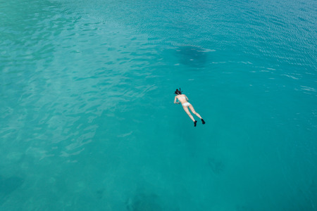 Young woman snorkeling in clear tropical turquoise watersの写真素材