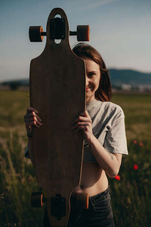 ordinary girl from the street. girl holds skate in hands. portrait of an ordinary girlの写真素材