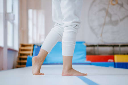 Close up of female hands touching safety mat, woman practicing gymnastic in gym. Detail woman footsの写真素材