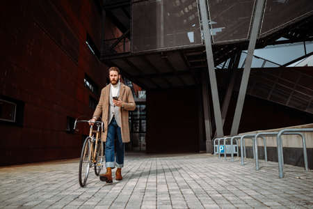 Businessman with bicycle going from work. Commuting. Male manager in business centre. Eco travelの写真素材