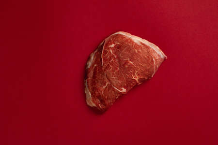 Raw beef meat steak isolated on a blood backgroundの写真素材