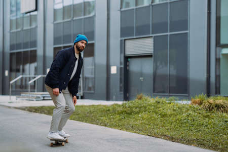 Man rides at skateboard . Modern building in backgroundの写真素材