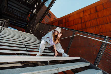 woman dancing on urban spat. Girl performing hip hop dance style having fun freestyle dancer in...