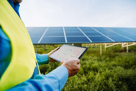 Worker using tablet for setting solar system. Eco concept