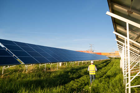 Worker in solar farm. Solar photovoltaic panels. Solar energy. Eco concept