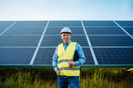 Worker or engineer stands front of solar panels looking at camera.の写真素材
