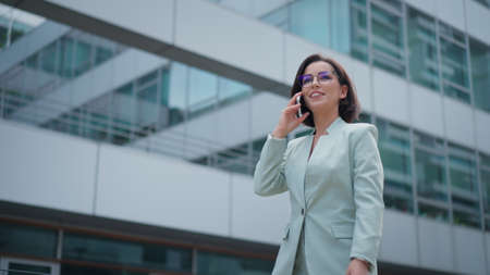 Portrait of beautiful caucasian female business leadership person who talking on cell phone dressed...