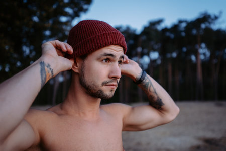 Concentrated man standing at the lake shore and looking at the waterの写真素材
