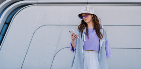 Cute attractive fashionable woman using phone in urban city buildings.の写真素材