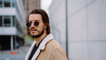 Portrait of young attractive man in casual clothes, wearing sunglasses and posingの写真素材