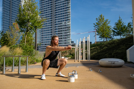 Fit man bending knees to full squat positionの写真素材