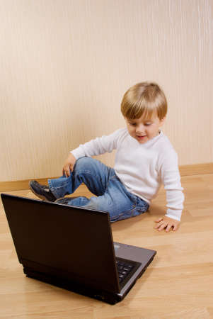 The child on the wood floor with laptopの写真素材