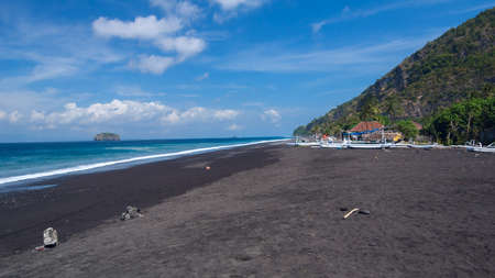 Junks on the beach of black sand on the island of Bali in Indonesia. Summer sunny day.の写真素材