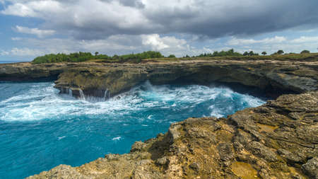 Waves on the rocks near the island of Lembongan near Bali, Indonesiaの写真素材