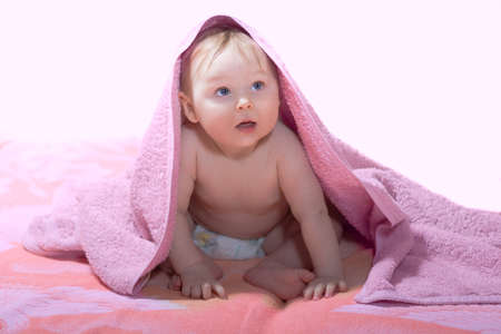 Little baby under pink towelの写真素材