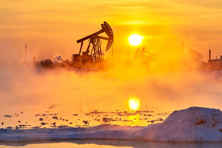The oil sucking machines in the vapour lakeside under sunrise.の写真素材