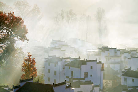 he morning fog on the dwellings of Anhui buildings in Wuyuan county Jiangxi province, China.の写真素材