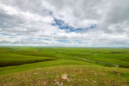 In July 2020, the Hulunbuir Prairie in Inner Mongolia, near Heishantou Town on the Sino-Russian border, is full of green grass, blue sky and white clouds, vast and high.の写真素材