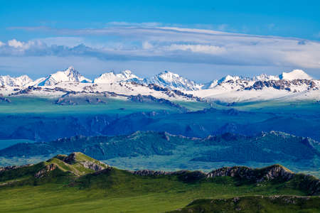 The beautiful scenery of snow-capped mountains and mists in the Bayinbulak grassland in Xinjiang.の写真素材