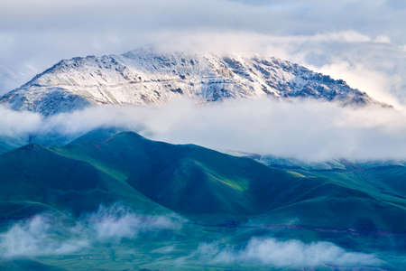 The beautiful scenery of snow-capped mountains and mists in the Bayinbulak grassland in Xinjiang.の写真素材