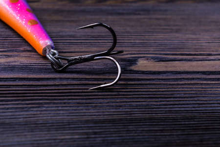 close up of fishing hook on a dark wooden background textureの写真素材
