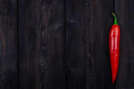 Red chili pepper on the dark wood texture background