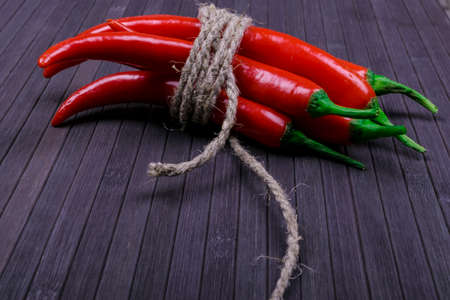Red hot  chili pepper on the dark wood texture backgroundの写真素材