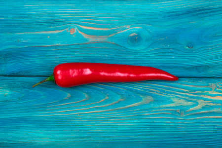 Red chili pepper on the blue wood texture backgroundの写真素材