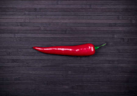 Red chili pepper on the dark wood texture backgroundの写真素材