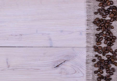Coffee beans on white wooden and burlap background textureの写真素材
