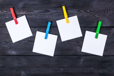 Clothespin hanging with blank photo papers on wooden background textureの写真素材