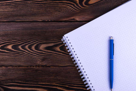 notebook and pen on a wooden table background