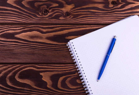 notebook and pen on a wooden table background