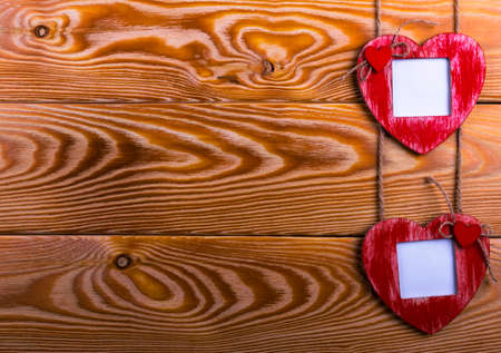 Love card template with blank photo frame heart shaped on the red hearts on wooden backgroundの写真素材