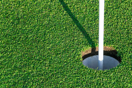 Golf hole on green grass of golf course. View of golf hole on green field.の写真素材