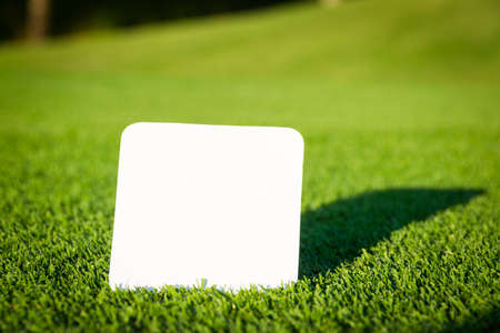 Empty blank white paper on green grass fieldの写真素材