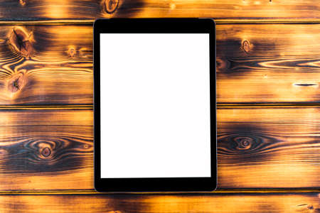 Tablet computer PC with blank screen mock up isolated on burned wood table background. Tablet on wood table. tablet white screenの写真素材