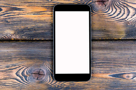 Mobile phone with blank screen mock up isolated on wood table background. Smartphone on wood table. Smartfone whiteの写真素材
