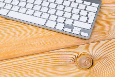 Business workplace with wireless keyboard on old natural wooden table background. Office desk with copy spaceの写真素材