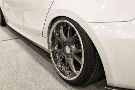 Tire and alloy wheel of a modern white car on the ground. car exterior details