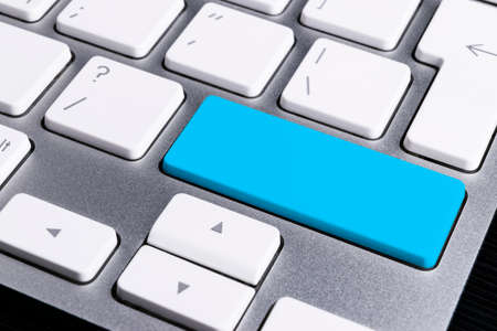 Close up view of a Computer notebook keyboard with one blue key, technology background, empty space for textの写真素材