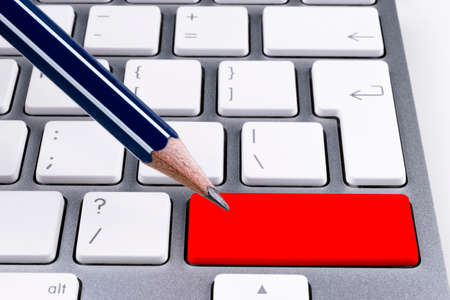Close up view of a Computer notebook keyboard with office pencil and one red button, technology background, empty space for textの写真素材