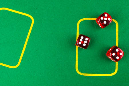 risk concept - playing dice on a green gaming table. Playing a game with dice. Red casino dice...