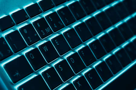 Business workplace with computer wireless keyboard on blue table background. Office desk with copy space in blue tonesの写真素材